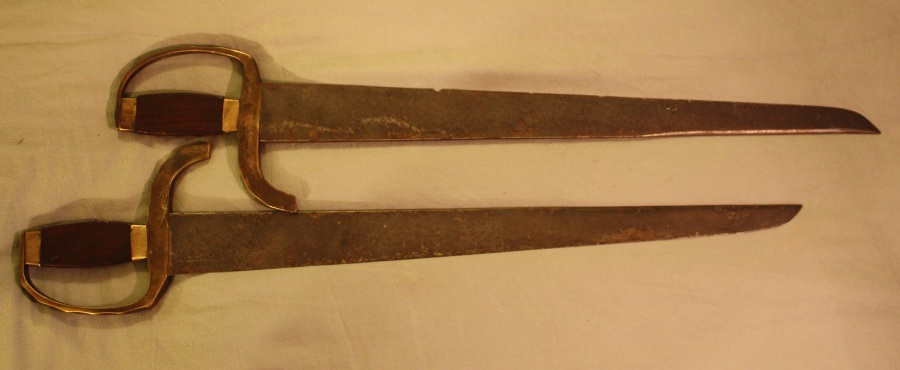These swords embody elements of both the longer copping ans stabbing types that were popular in the 19th century.  Both blades are finely made, well balanced and exhibit long false edges.  Total length: 60 cm; Width at bade: 5 cm, width of spine: 10 mm. Source: Author's Personal collection.