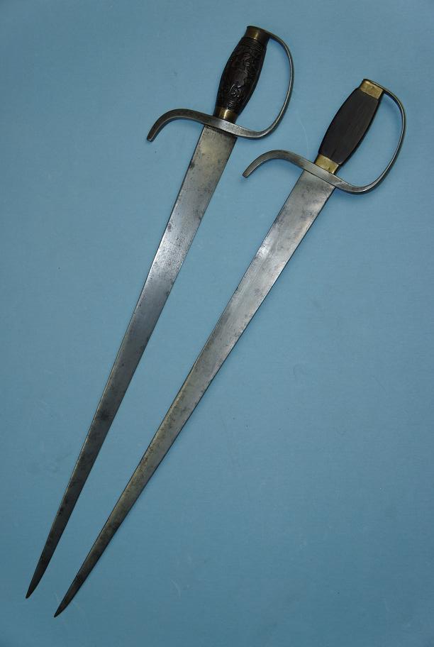A set of mid. 19th century hudiedao.  These swords are 63 cm long have strong blades with a thick triangular spine (14 mm at the forte).  They were capable of cutting but clearly optimized for stabbing.  The edge itself has a convex grind on one side, and a flat grind where it sits against the other sword when sheathed.  The blades also feature steel D-guards and rosewood handles decorated with carved phoenixes.  This images was provided courtesy of http://www.swordsantiqueweapons.com, a reliable source for authentic antique Chinese arms.