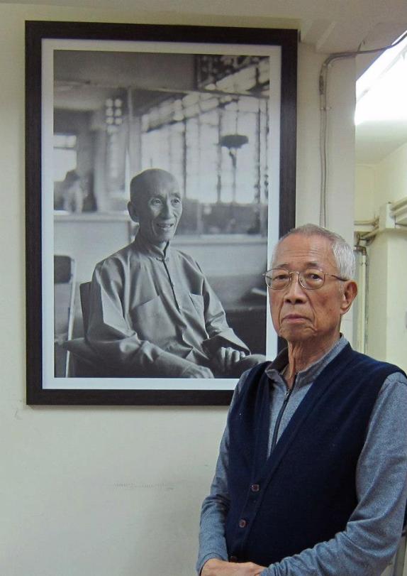 Wing Chun Master Chu Shong Tin standing next to the portrait of his teacher, Ip Man. Source: http://pangea.com.hk
