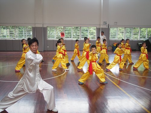 Chen Daoqing, a third-generation practitioner of Mian Quan, leads students practicing moves at Shanghai Kunming Primary School.  Source: Global Times